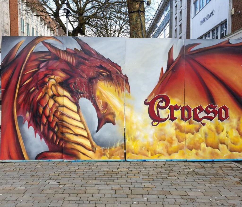 Croeso Festival: Image of a dragon breathing fire with 'Croeso' text - Painted by James Burgess, Founder of Fresh Creative Co