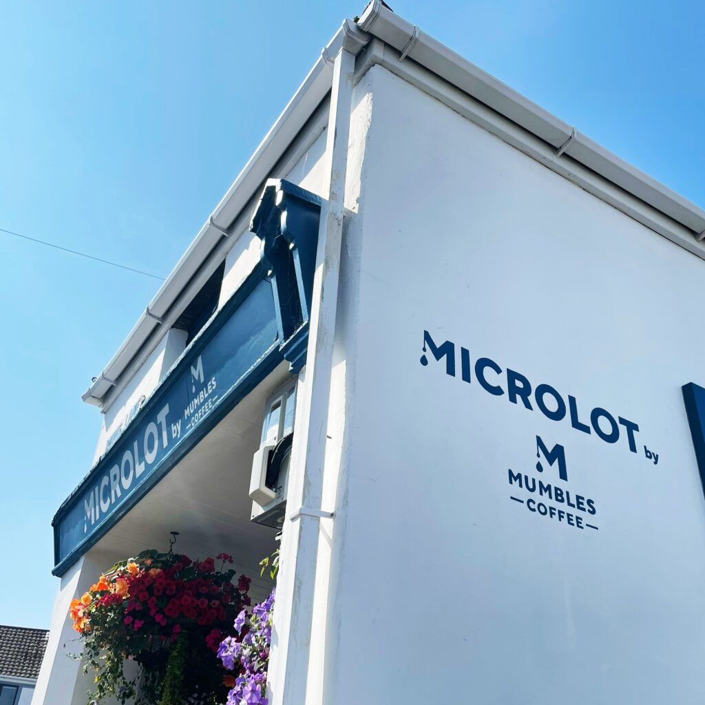 Side shot of Microlot by Mumbles sign painted on side wall of shop
